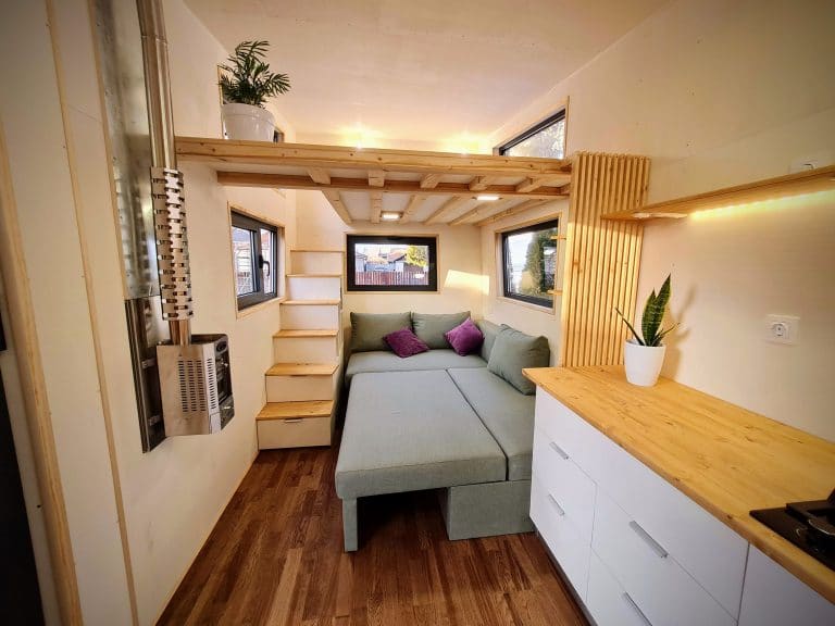 tiny house on wheels with a double bed couch